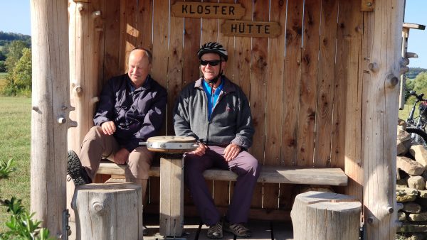 zwei Touristen sitzen in der Klster-Dreh-Hütte.